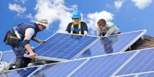 3 people hold a solar panel